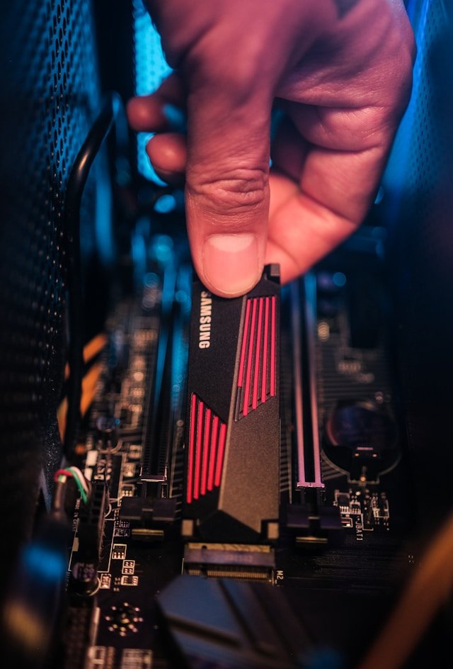 Computer hardware probleem diagnose Eindhoven reparatie pc binnenkant / Photo by <a href="https://unsplash.com/@samsungmemory?utm_source=unsplash&utm_medium=referral&utm_content=creditCopyText">Samsung Memory</a> on <a href="https://unsplash.com/photos/a-hand-holding-a-black-and-red-electronic-device-SQ_qLx9uugc?utm_source=unsplash&utm_medium=referral&utm_content=creditCopyText">Unsplash</a>